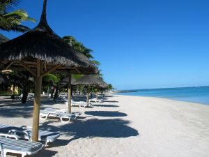 Lækker badestrand på Mauritius med liggestole, parasoller og det azurblå hav i baggrunden
